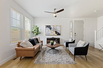 A living room with a brown couch, a coffee table, and a painting on the wall.